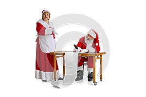 Emotional Santa Claus and his wife, missis Claus congratulating with New Year and Christmas, writing a letter, wish list