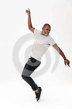 Emotional screaming young african man dancing isolated