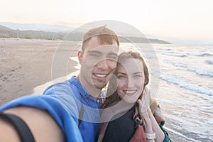 Emotional selfie of a young couple on the sea coast at sunset