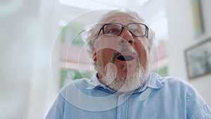 Emotional senior man smiling at home. Closeup mature man with positive emotion