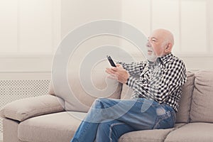 Emotional senior man watching tv copy space