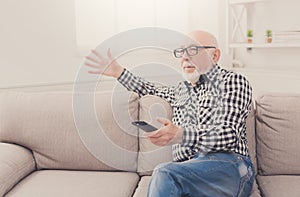 Emotional senior man watching tv copy space