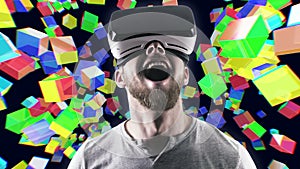 Emotional smile happy man wearing virtual reality goggles. VR headset. Within virtual space cubes black look up