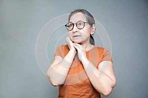 Emotional surprised middle-aged woman on   gray background