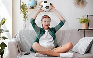 Emotional teen boy watching football match at home, celebrating win