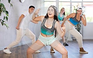 Emotional teen girl dancing krump with group in modern studio