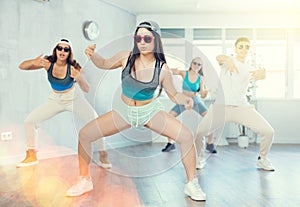 Emotional teen girl dancing krump with group in modern studio