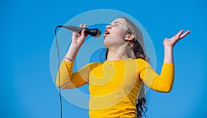 emotional teen girl singing karaoke in microphone