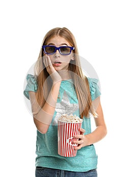 Emotional teenage girl with 3D glasses and popcorn during cinema show