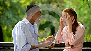 Emotional teenagers arguing and quarreling sitting on bench in park, conflict