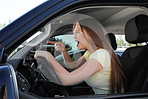 Emotional woman in car. Aggressive driving behavior