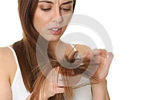 Emotional woman with damaged hair on white background.