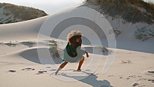 Emotional woman dance desert at summer. African american girl performing on sand