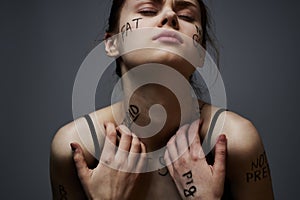 Emotional woman with inscriptions on her body gestures with hands lifestyle frustration stress gray background