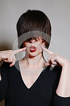Emotional woman portrait with red lips and dark short hair