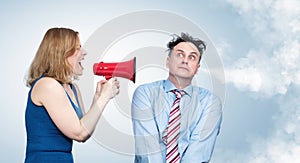 Emotional woman screaming through a red megaphone at a frightened man in a shirt and tie with steam coming out of his ear