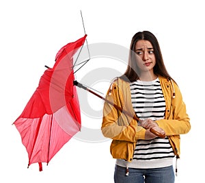 Emotional woman with umbrella broken by gust of wind on white background