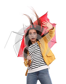 Emotional woman with umbrella caught in gust of wind on white background