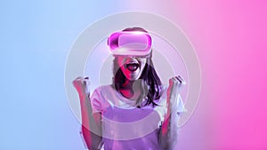 Emotional woman wearing vr glasses, raising fists up