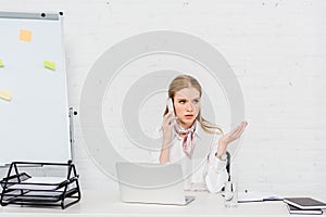 emotional young businesswoman talking by phone