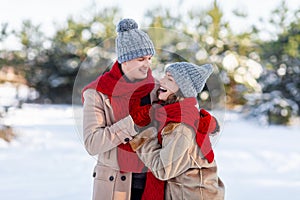 Emotional young couple having fun while walking by winter forest