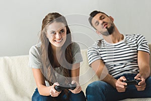 emotional young couple playing games with gamepads