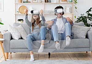 Emotional young family playing video games at living room