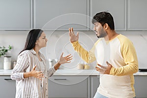 Emotional young indian couple fighting at kitchen