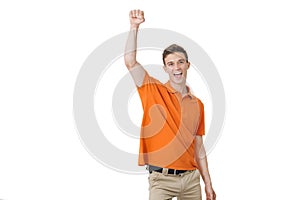 Emotional young man with brown hair screaming and raising hands in the air, feeling excited. Success concept