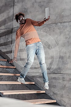 Emotional young man keeping balance on stairs