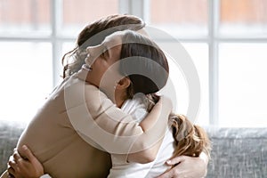 Emotional young mixed race girl embracing glad senior mature mother. photo