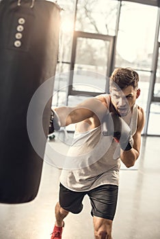 emotional young sportsman training with punching bag