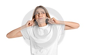 Emotional young woman covering her ears with fingers on white background