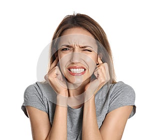 Emotional young woman covering her ears with fingers on white background