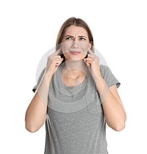 Emotional young woman covering her ears with fingers on white background