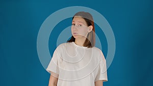 Emotional young woman says Wow posing on blue background