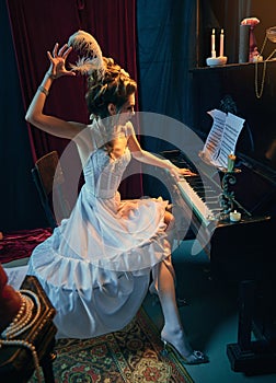 Emotionally performing. Portrait of beautiful young girl in image of medieval princess in white elegant dress sitting at