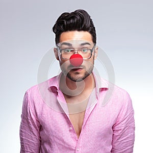 Emotionless fashion young man with red nose