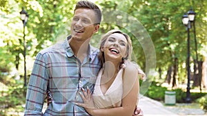 Emotions of cheerful young couple enjoying romantic date in summer park, slow-mo