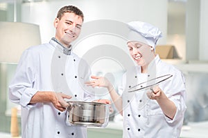 Emotions of cooks, portrait with soup pot on the background