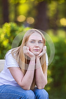 Emotions of the girl, fatigue, boredom, depression, sadness. Attractive bored young blond Caucasian woman holding her head with ha