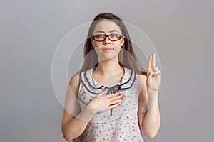 Emotions and people. A young woman in a blouse and glasses swears allegiance photo