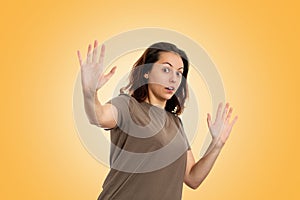 Emotions. Portrait of frightened young caucasian woman stressful keeping hands, terrified in panic. Yellow background. Human