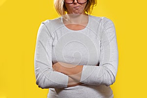 Emotions and psychology. The woman, a blonde with glasses, crossed her arms and pursed her lips with a disgruntled face. Close up
