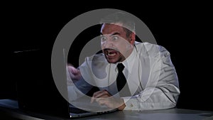 Emotions rage. A man sitting at his laptop in anger