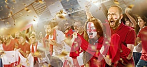 Emotive football, soccer fans from England cheering their team with white red scarfs at stadium. Concept of sport