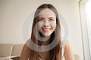 Emotive headshot portrait of smiling young woman photo