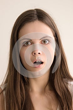 Emotive headshot portrait of stunned young woman photo