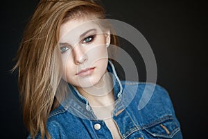 Emotive portrait of a young beautiful girl with curly long hair posing over black background. Perfect skin and hair. Spa salon. Cl