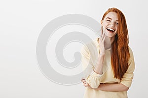 Emotive redhead girl grinning from happiness. Portrait of charming young european female with ginger hair feeling